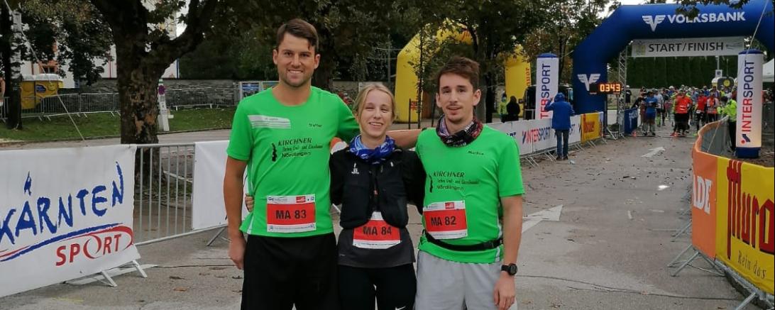 Zwei Läufer und eine Läuferin stehen auf einer Laufstrecke