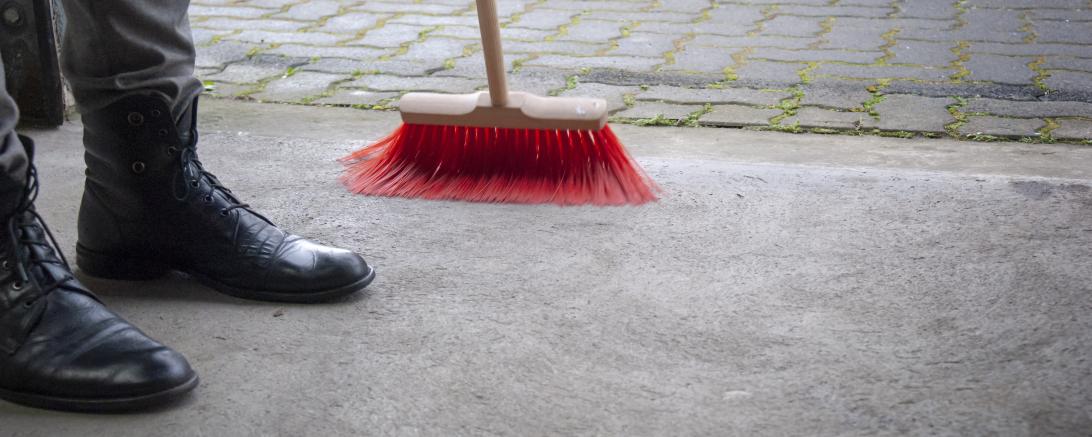 Straße wird mit Besen gekehrt