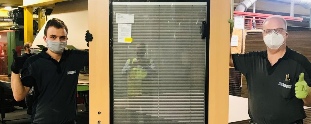 Das Bild zeigt Jonas Herrmann und Heiko Kogel aus der technischen Verglasung, die stolz die 1.000.000 Tür des Jahres 2020 präsentieren.