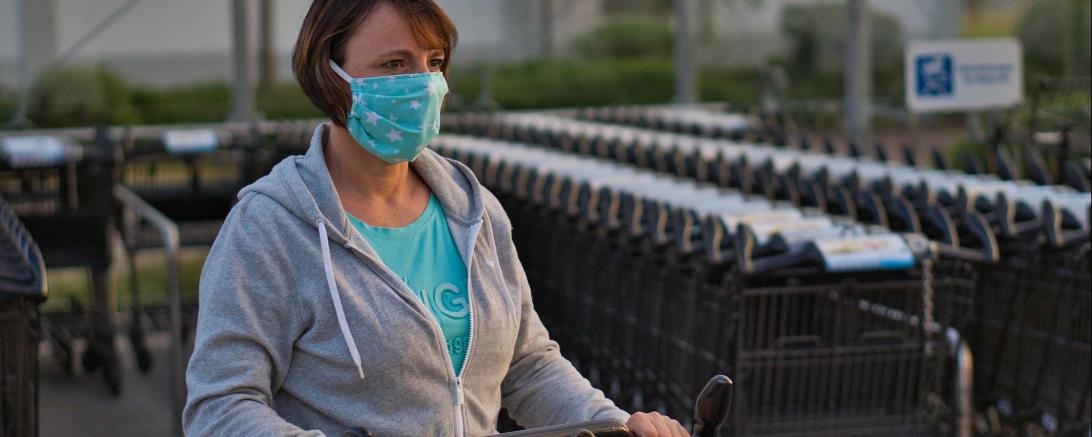 Frau mit Einkaufswagen und Mundschutzmaske