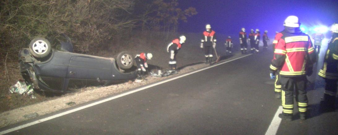 Verunglückter Pkw im Straßengraben, dabei Feuerwehrleute