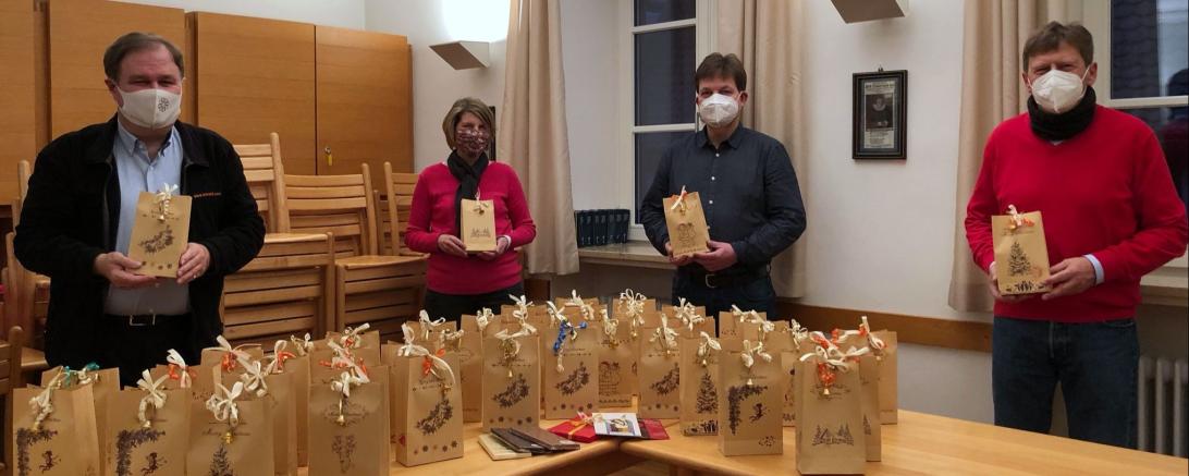 Vier Personen mit Maske und Geschenken