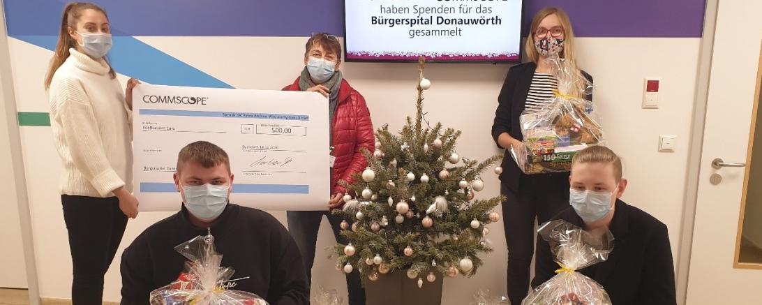 Fünf Personen mit Maske und Geschenken