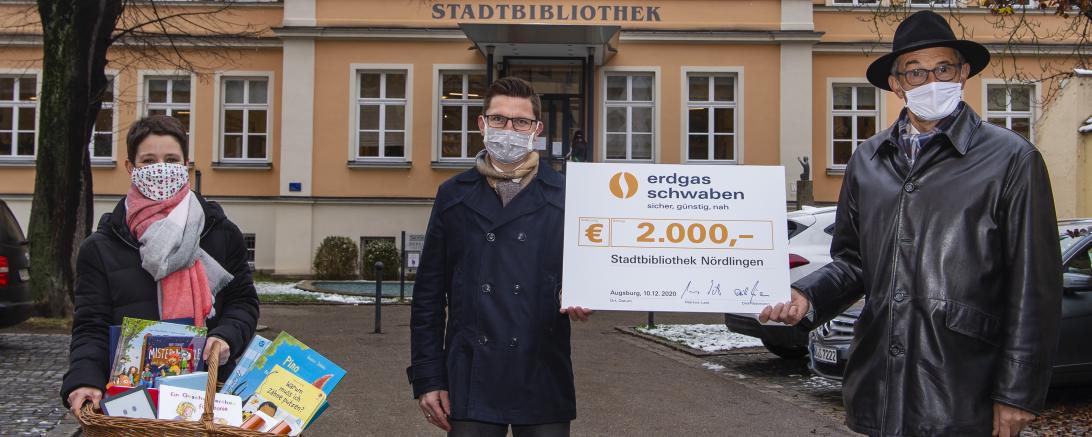 Kathrin Häffner, David Wittner, Helmut Kaumeier mit Spendenscheck und Bücherkorb