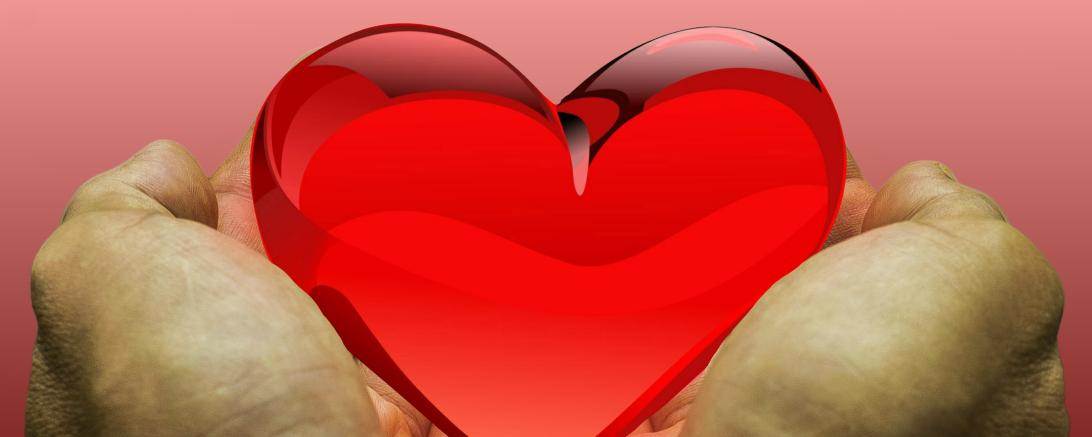 Hände, die ein rotes Herz halten