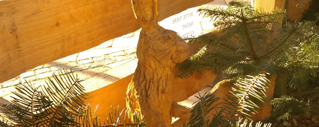 Hölzerne Hasenskulptur an einem Holzzeun