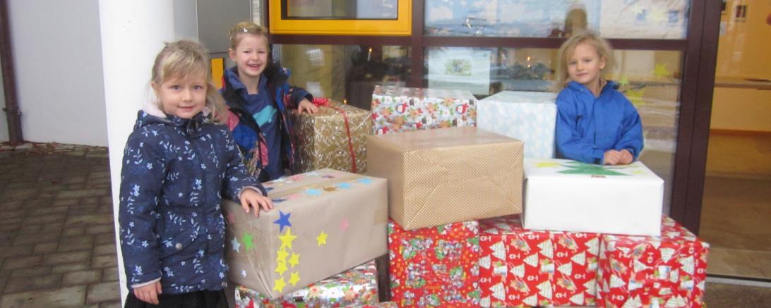 Auf dem Bild präsentieren Johanna, Marie und Frida stolz die Pakete, die kurz darauf vom großen Johanniter-Fahrzeug, sogar mit Blaulicht, abgeholt wurden.