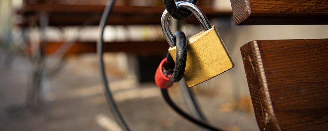 Das Bild zeigt ein Schloss, welches an einer Bank befestigt ist