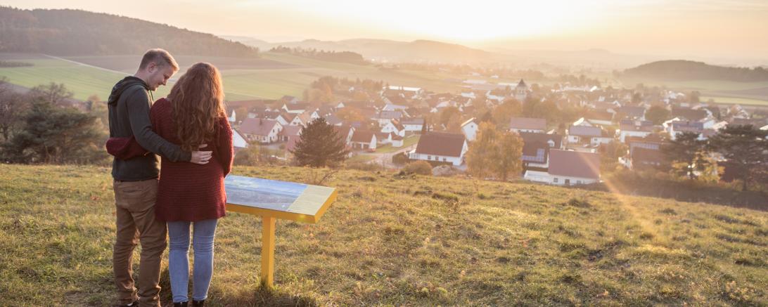 Pärchen vor Lehrtafel auf Weg des Ferienlandes Donau-Ries