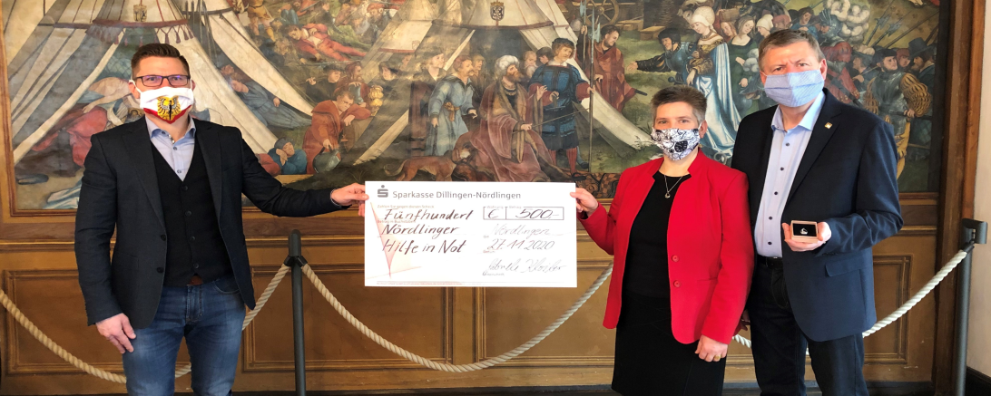 Gabriele und Armin Kloiber, Inhaber der Goldschmide Herrle & Schweda, spenden 500 Euro aus den Verkaufserlösen des eigens gestalteten „Nördlingen Anhängers“ an die „Nördlinger Hilfe in Not“ und präsentieren den Scheck und den Anhänger Oberbürgermeister David Wittner. 