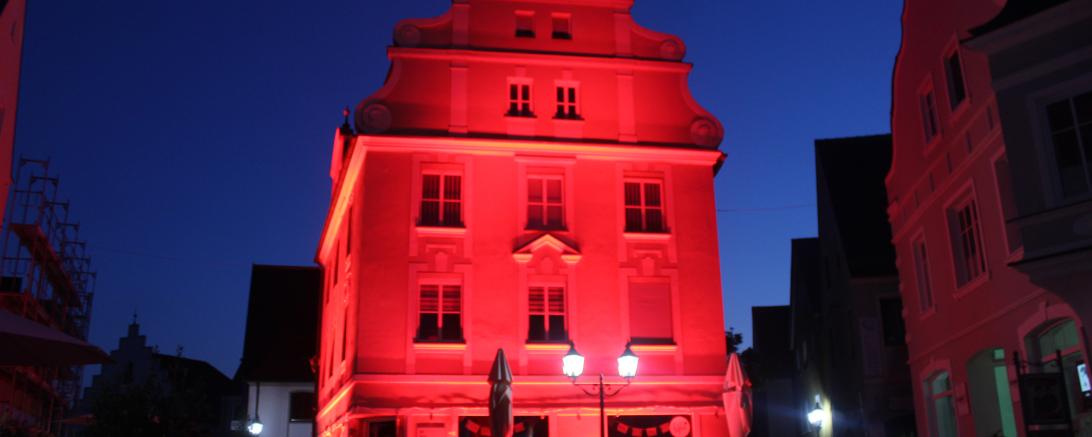 Das Bild zeigt das Café La Kami im Donauwörther Ried mit rotem Licht angestrahlt.