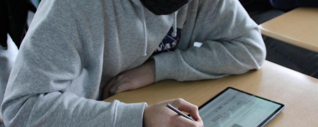 Das Bild zeigt einen Jungen am Tablet.