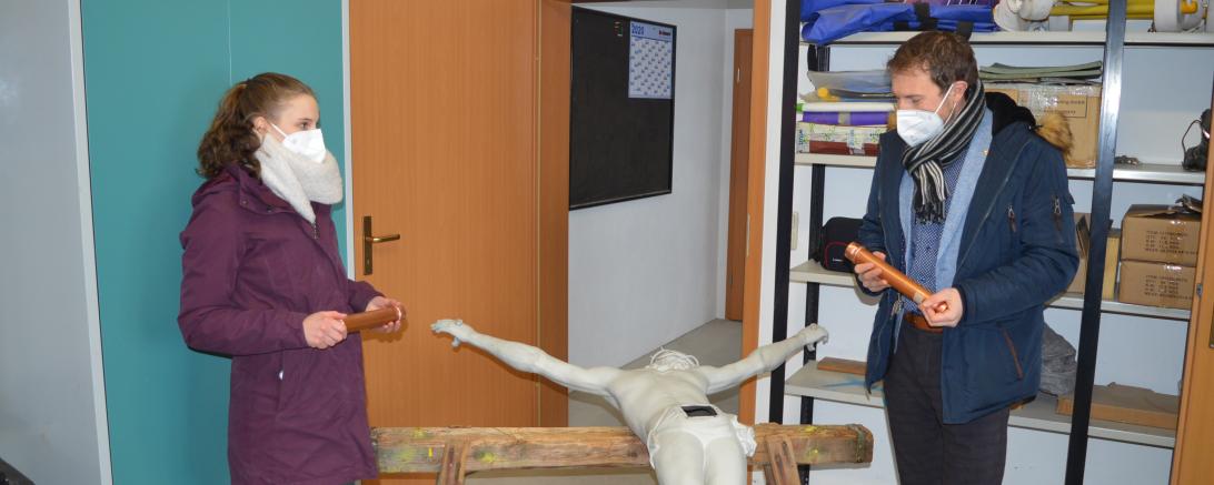 Das Bild zeigt Bürgermeister Thomas Heydecker und Michelle Grieb, Mitarbeiterin des Bauamts,  wie sie die Christus-Figur mit den Zeitkapseln befüllen.