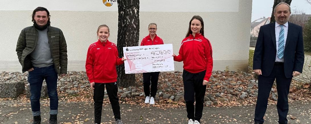 Fünf Personen mit Spendenscheck vor Schule Wallerstein