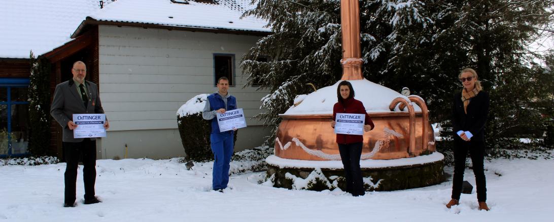 Ralf Winkler (Ladebereich), Jörg Gruber (Abfüllung), Katja Maier (Personal) und Pia Kollmar (Geschäftsführerin) bei der Scheckübergabe.