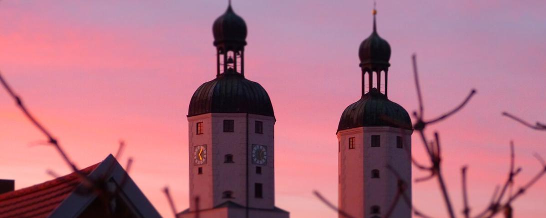Das Bild zeigt die Wemdinger Stadtpfarrkirche bei Sonnenuntergang. 