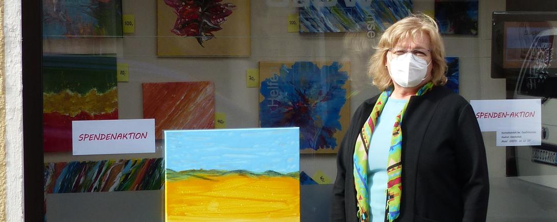 Das Bild zeigt Gudrun Handschuh mit einem ihrer Bilder. 