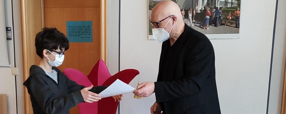 Das Bild zeigt Johann Enderle vom Autorenclub, der Robert Mährle, dem Sieger des Schreibwettbewerbs, seinen Preis überreicht.