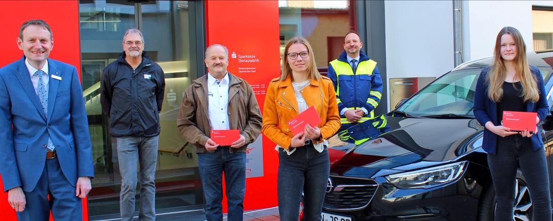 Das Bild zeigt die Übergabe der Sparbücher