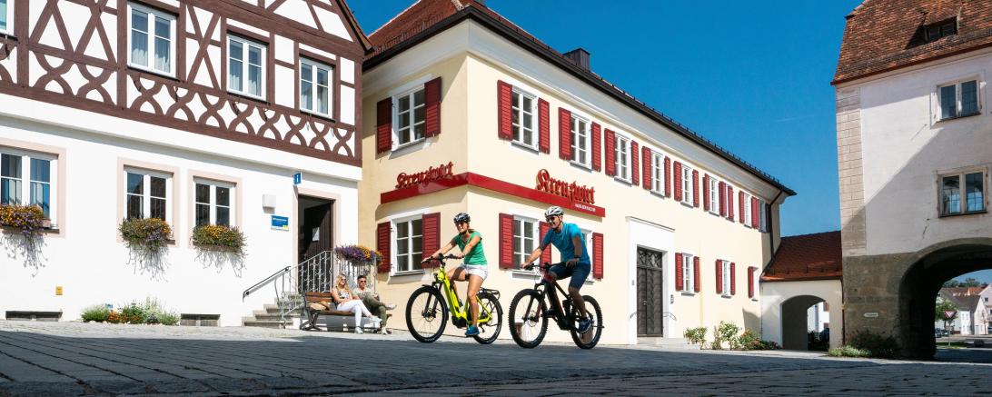 Das Bild zeigt zwei Radfahrer in der Monheimer Innenstadt. 