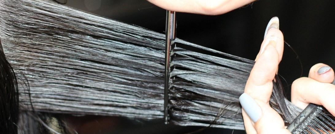 Das Bild zeigt Haare die gerade geschnitten werden.