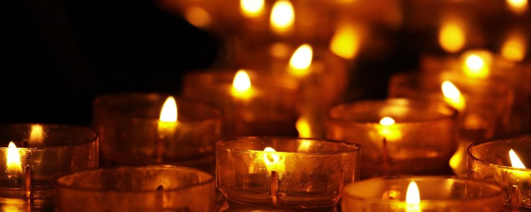Das Bild zeigt mehrere Kerzen, die in Gedenken an die Verstorbenen angezündet wurden.