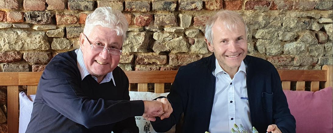 Das Bild zeigt den Hama Geschäftsführer Christoph Thomas bei der Vertragsunterzeichnung mit Bruno Messingschläger. 