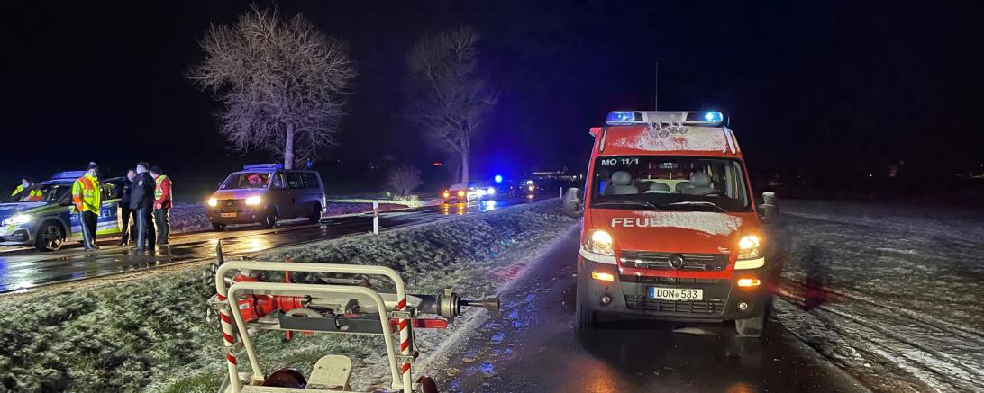 Feuerwehrauto und Polizeiautos stehen an Straßenrand