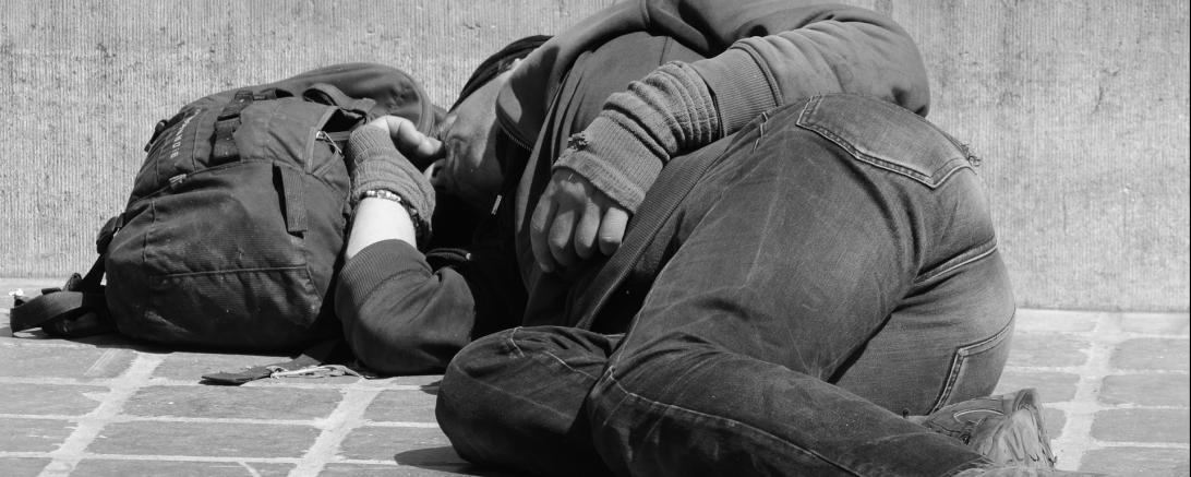 Das Bild zeigt einen obdachlosen Mann.