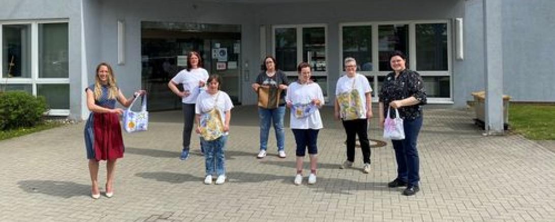 Das Bild zeigt Konversionsmanagerin Barbara Wunder, die Mitarbeiterinnen des Nähteams Christina Blischke, Silke Kloß, Chrisi Hertle, Julia Rau, Moni Büttner und Mensaleitung Simone Straß.