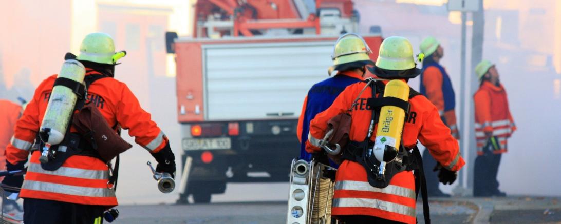 Das Bild zeigt Feuerwehrmänner bei einem Brandeinsatz.