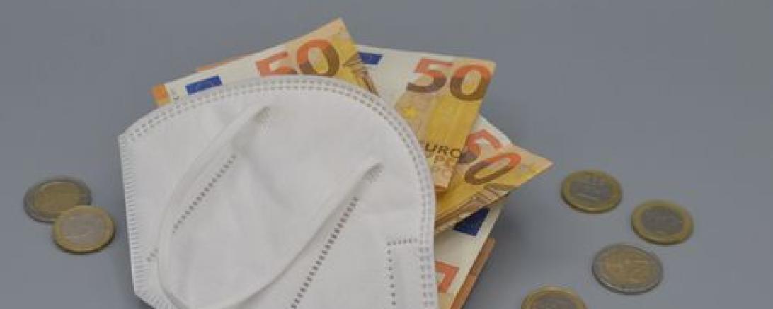 Das Bild zeigt eine FFP2-Maske mit Geld drinnen