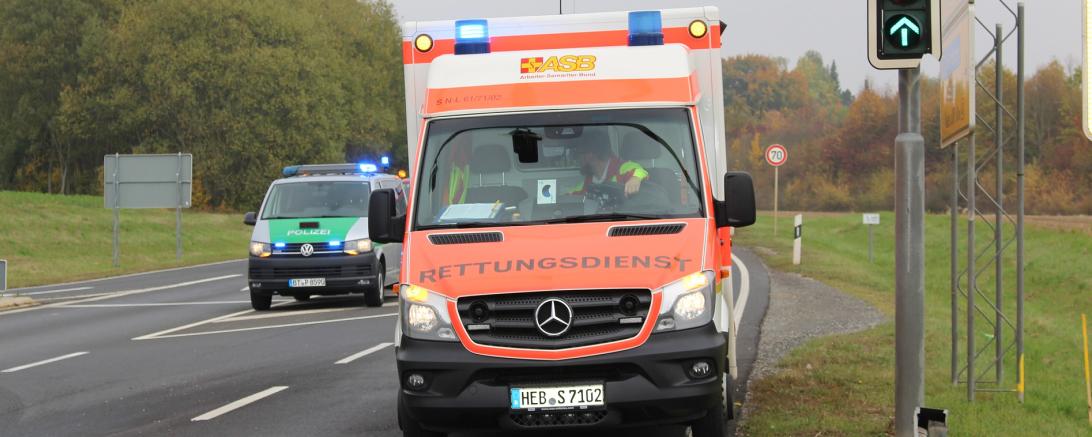 Das Bild zeigt einen Krankenwagen und ein Polizeiauto.