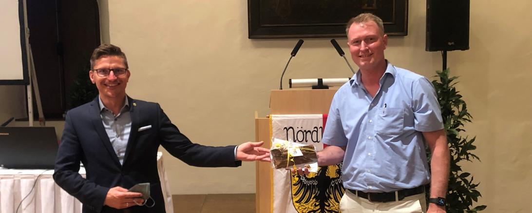 Oberbürgermeister David Wittner dankt Stadtbaumeister Hans-Georg Sigel mit einem besonderen Geschenk: Ein „Nördlinger Stadtmauer Schreiber“ aus Stadtmauerholz soll ihn an seine Zeit in Nördlingen erinnern.