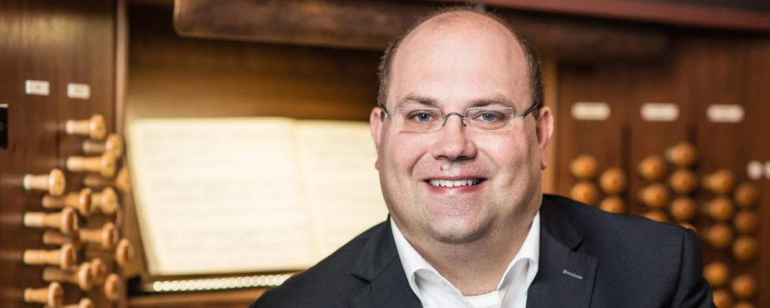 Mann im Anzug vor Kirchenorgel