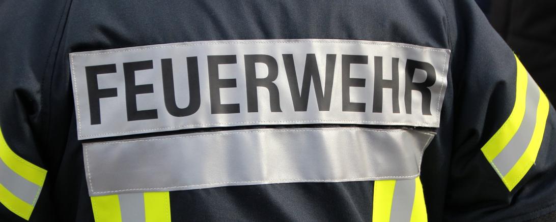 Das Bild zeigt die Aufschrift "Feuerwehr" auf einer Weste. 