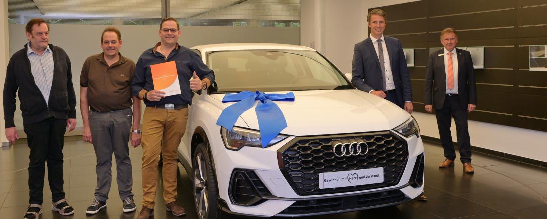 Zusammen mit Vater und Zwillingsbruder holt Achim Stahl (in der Mitte) sein neues Auto im Audi Forum Ingolstadt ab. Regionaldirektor Thomas Schwair von der Raiffeisen-Volksbank Donauwörth eG (zweiter von rechts) gratuliert dem glücklichen Gewinner.
