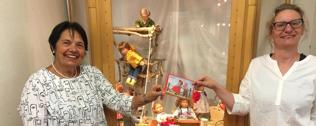 Das Bild zeigt zwei Frauen beider Übergabe eines Spendenumschlags. 