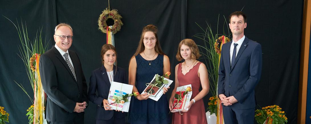 Schulleiter Gerhard Härpfer und Klassenleiter Matthias Buchner gratulieren Franziska Burzler, Ellen Berger und Lena Bauer zur Traumnote 1,00. 