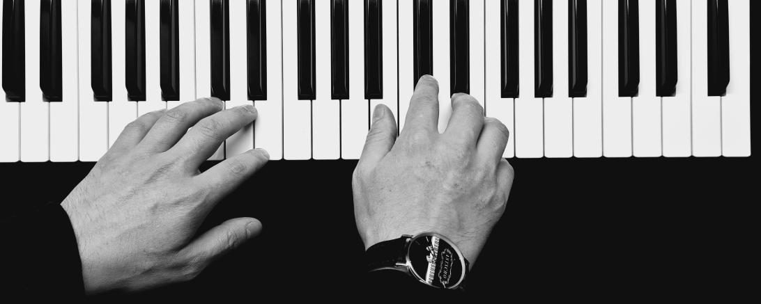 Schwarz-weiß-Bild von Händen an einer Klaviatur