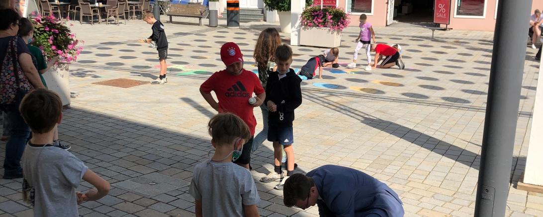 Kinder der Grundschule Mitte mit Außenstel-le Baldingen gestalten die Nördlinger Innenstadt mit Kreide-kunstwerken an den Fußwegen bunt, welche vom Oberbürgermeister David Wittner bewundert wurden.