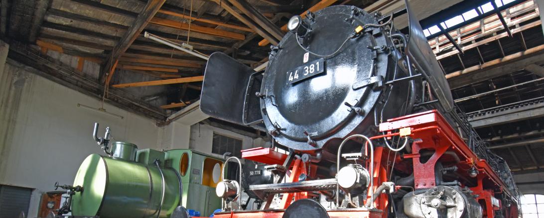 Schwarze und grüne Dampflok in einer Halle