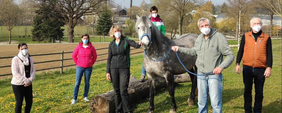 Das Bild zeigt eine Gruppe Menschen mit dem Therapiepferd Renia.