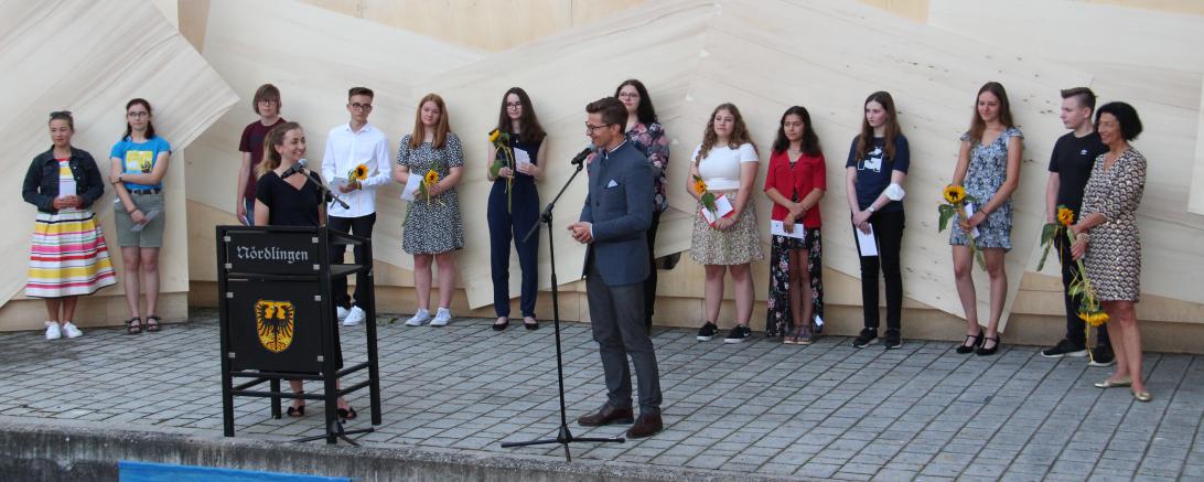 Der ersten Nördlinger Stadtschreiberin Stephanie Quitterer wird im Rahmen einer Abschlussveranstaltung für ihren besonderen Einsatz gedankt. Vorne von links: Stephanie Quitterer (Stadtschreiberin) und Oberbürgermeister David Wittner. Hinten von links: Schülerinnen und Schüler der Realschule Maria Stern mit Lehrerin Eva von Roda.