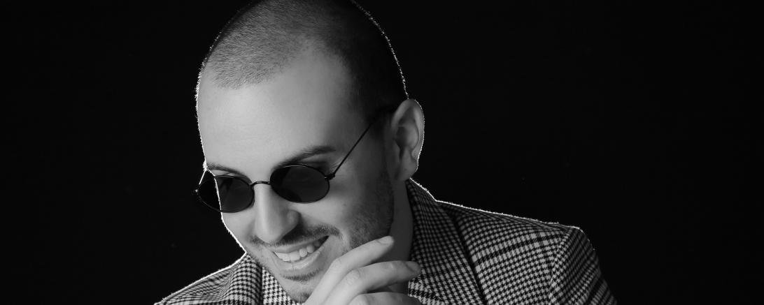 Mann mit Sonnenbrille und Armbanduhr faltet die Hände