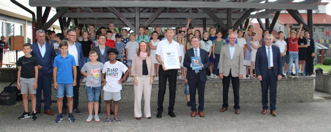 Mehrere Personen, darunter viele Kinder, vor einer Überdachung