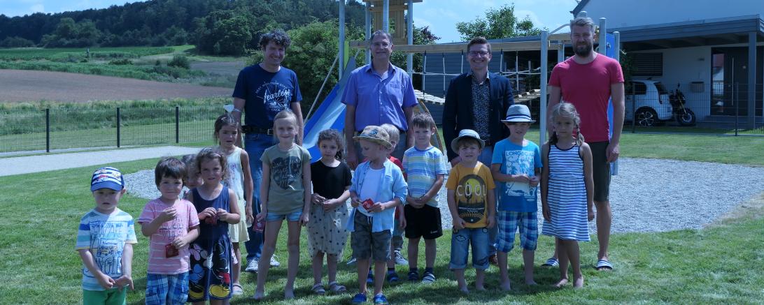 Von links hintere Mitte: Michael Stiller (Ortssprecher Herkheim) und Oberbürgermeister David Wittner, umgeben von Kindern und Eltern aus Herkheim
