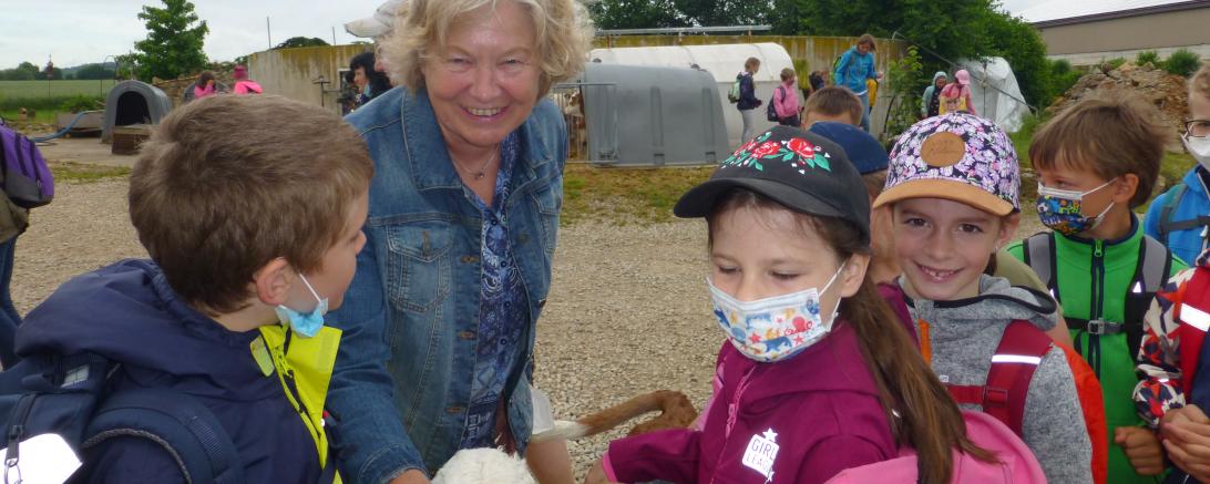 Kreisbäuerin Ruth Meißler mitten unter den Kindern beim Kälberauslauf