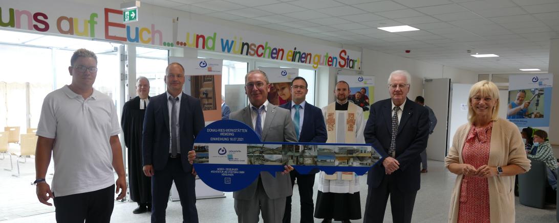 Auf dem Bild zu sehen (von links): Werkstattrat Mickel Schwab, Pfarrer Horst Kohler, Architekt Helmut Guckert, Geschäftsführer der Lebenshilfe Günter Schwendner, Werkstattleiter Tobias Brucklacher, Pfarrer Wolfgang Gebert, 1. Vorsitzender der Lebenshilfe Paul Kling und Staatsministerin Carolina Trautner. 