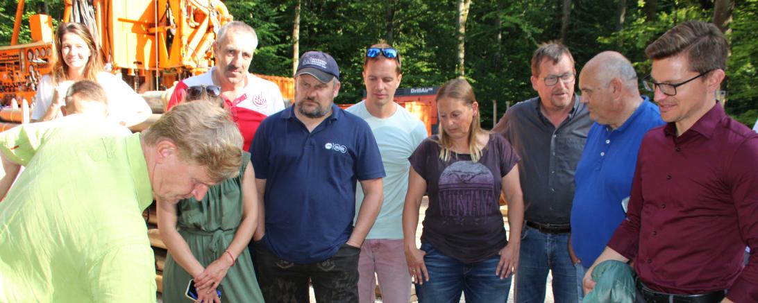 Elf Personen stehen vor Bohrgerät